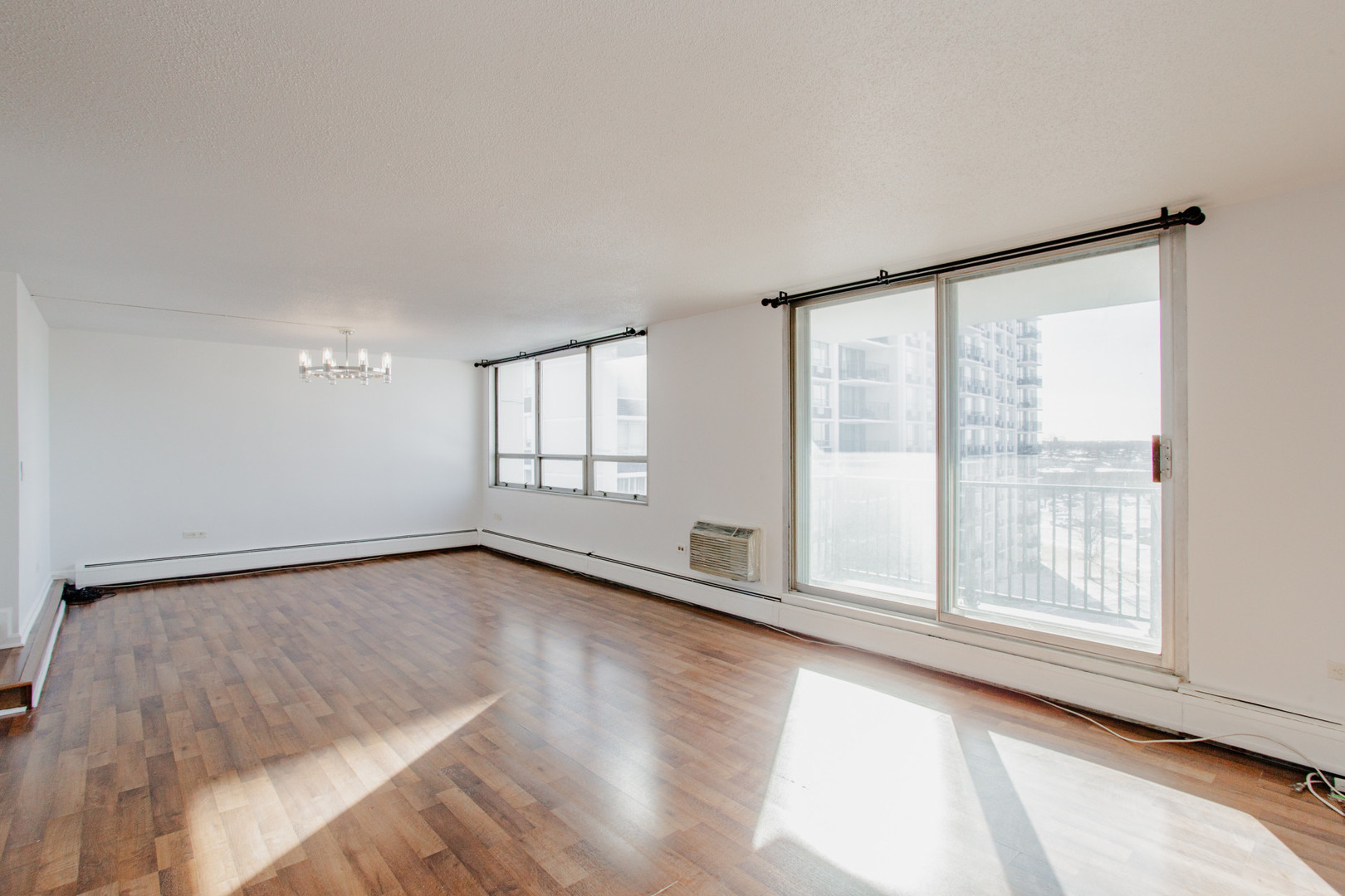 8801 West Golf Road, Unit 6B Niles, IL 60714 - Photo 3 of 13 a view of an empty room with a window and wooden floor