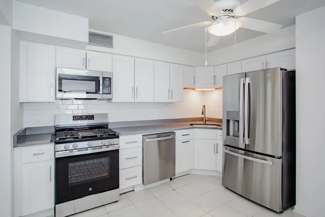 a kitchen with cabinets stainless steel appliances and a counter space