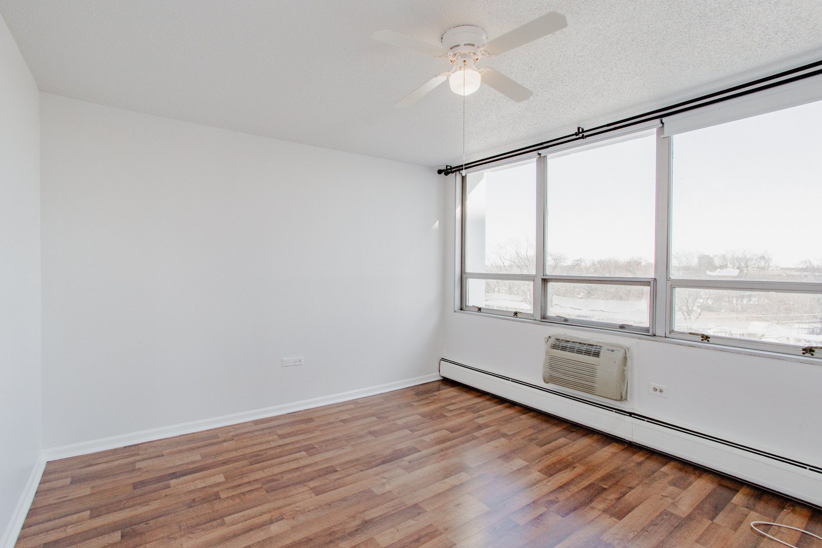 8801 West Golf Road, Unit 6B Niles, IL 60714 - Photo 5 of 13 an empty room with wooden floor and windows