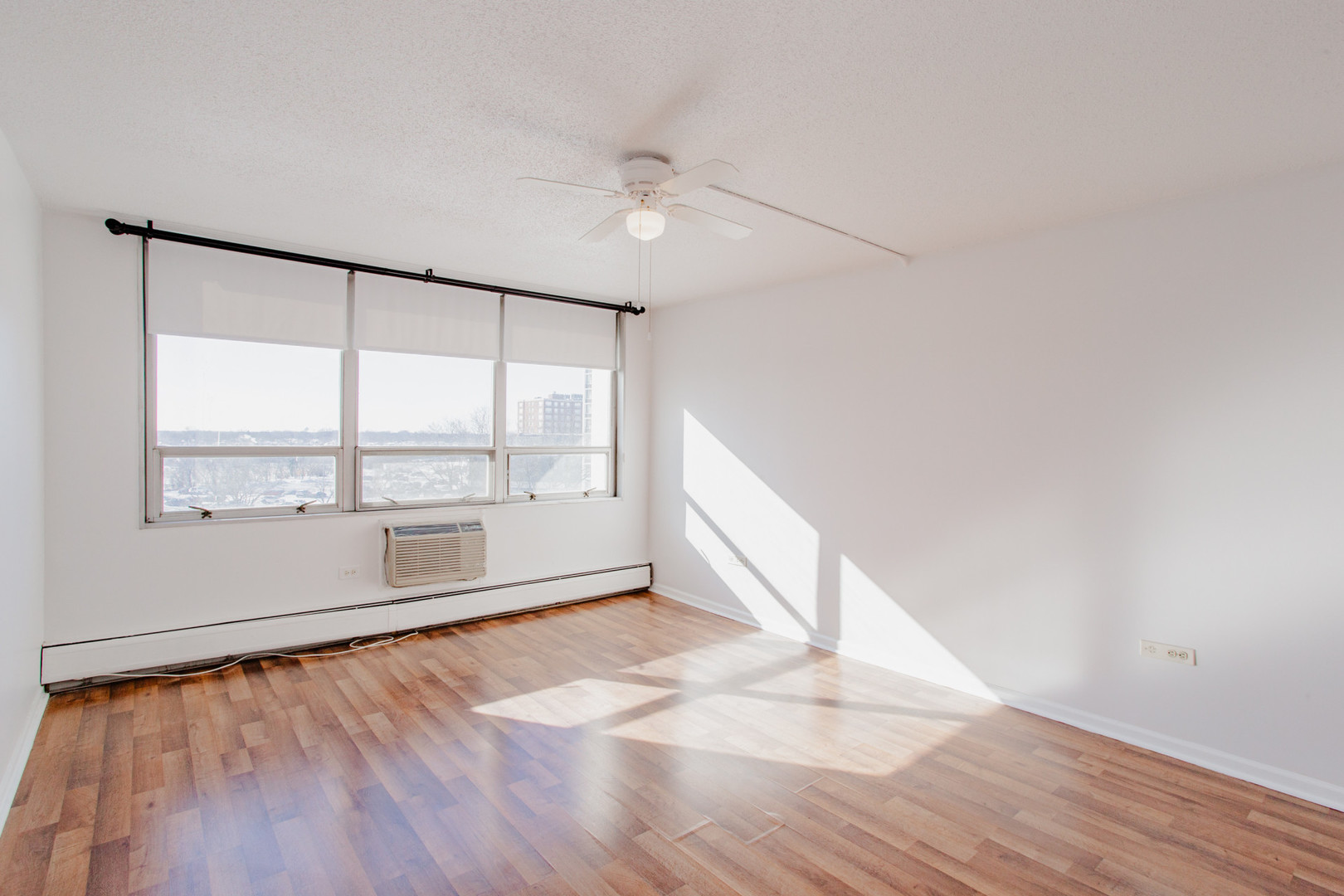 8801 West Golf Road, Unit 6B Niles, IL 60714 - Photo 8 of 13 an empty room with wooden floor and windows