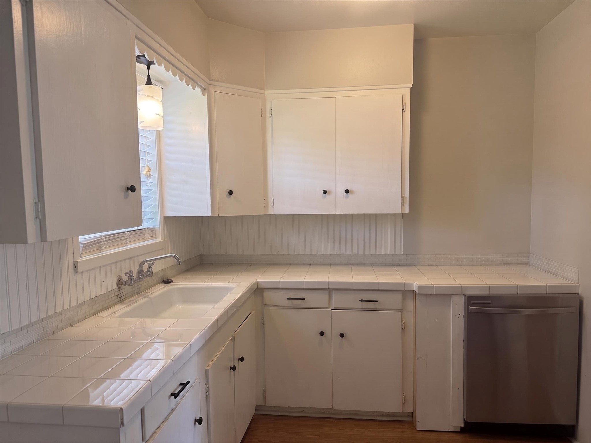 2313 Avenue L Rosenberg, TX 77471 - Photo 12 of 31 Alternate view of the kitchen showcasing generous counter space, extensive storage, and stainless steel dishwasher.