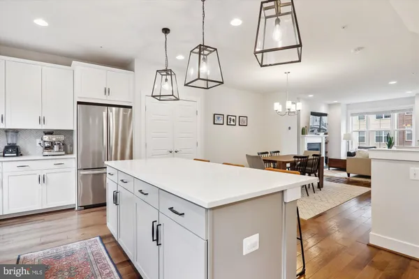 a kitchen with stainless steel appliances granite countertop a stove a sink a refrigerator a stove a microwave and wooden floor