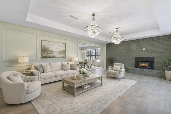 a living room with furniture chandelier and a fireplace