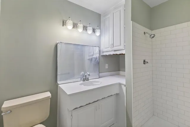 a bathroom with a sink a toilet and shower