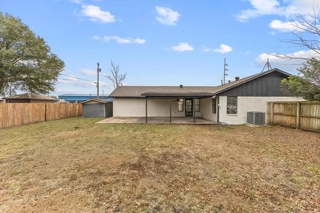 a view of a house with a backyard and a tree