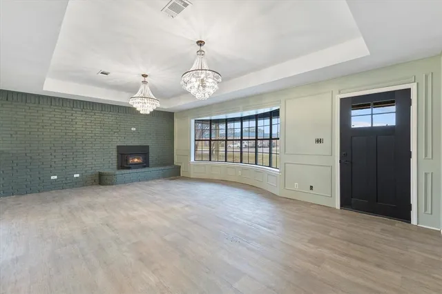 an empty room with chandelier and windows