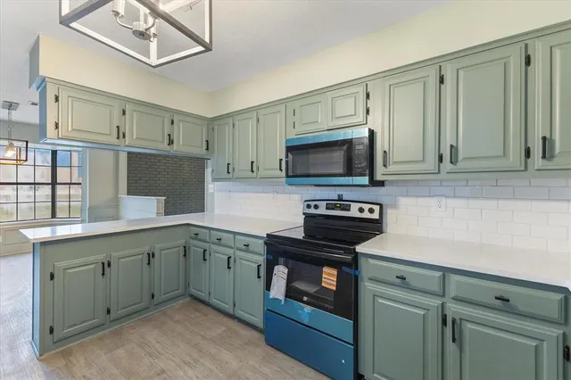 a kitchen with stainless steel appliances granite countertop a stove a sink and a microwave