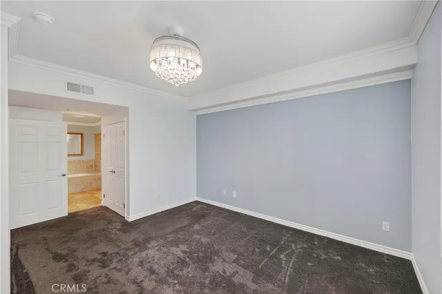 a view of an empty room and a chandelier fan