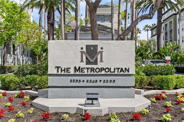 a view of sign board with buildings and plants