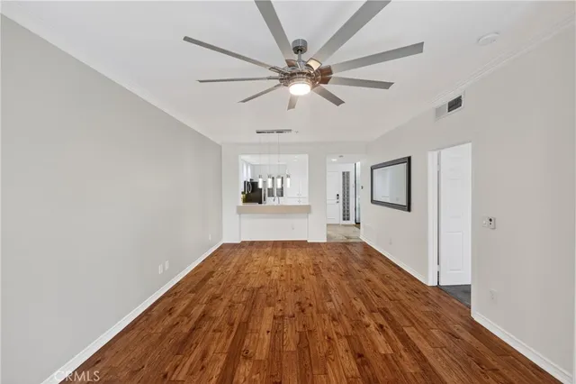 a view of a livingroom with wooden floor and a ceiling fan