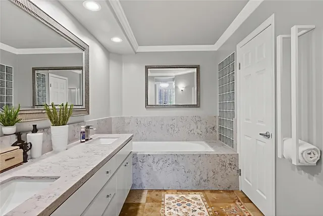 a bathroom with a granite countertop sink a mirror a bathtub and shower