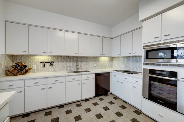 a kitchen with granite countertop white cabinets stainless steel appliances and sink
