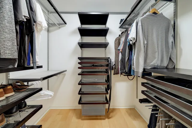 a view of walk in closet with clothes and shoes