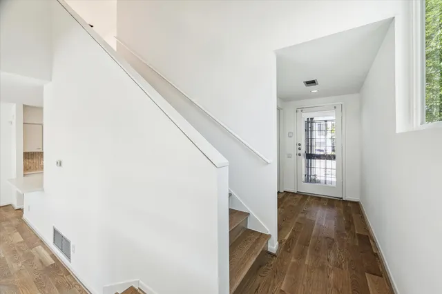 a view of hallway with wooden floor and staircase