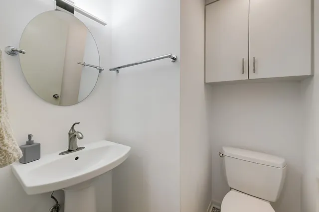 a bathroom with a toilet a sink and mirror
