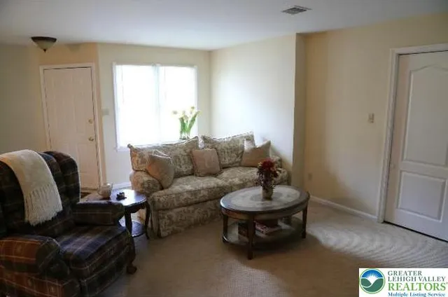 a living room with furniture a flat screen tv and kitchen view