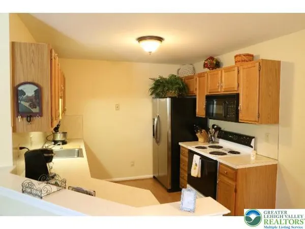 a kitchen with a sink a refrigerator and cabinets