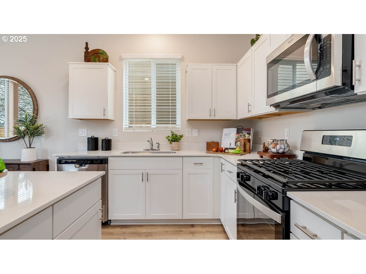 1095 Stubb Road Northeast Woodburn, OR 97071 - Photo 10 of 37 a kitchen with a stove a sink and a microwave