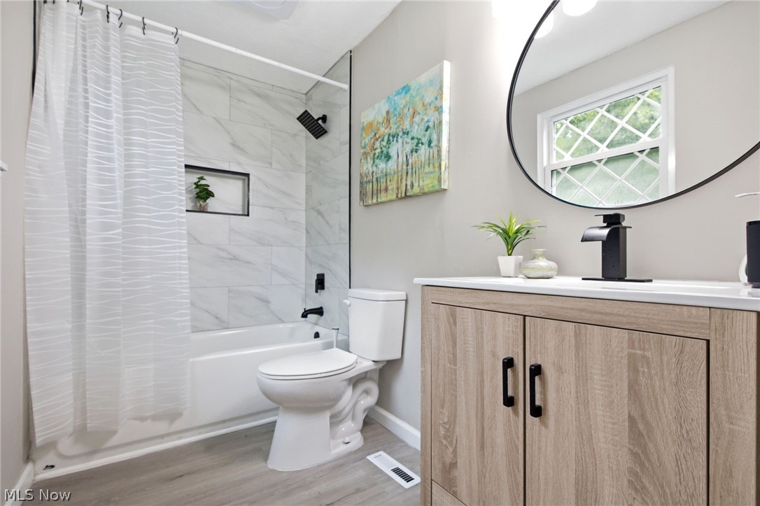 7012 Roe Boulevard Madison, OH 44057 - Photo 23 of 30 Bathroom with light wood-finish vanity, white countertop, and black waterfall-style faucet
