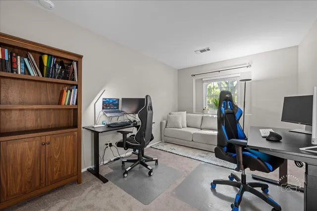 a view of a workspace with furniture and a bookshelf