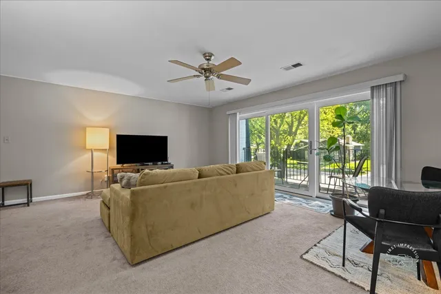 a living room with furniture a flat screen tv and a large window