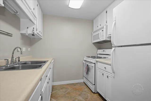 a kitchen with cabinets and white stainless steel appliances