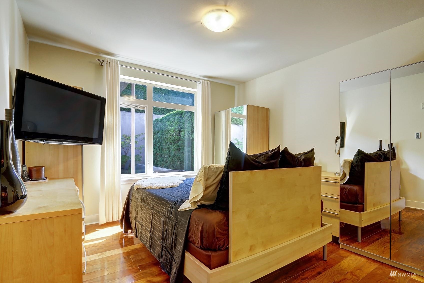 41 Pine Street, Unit 213 Edmonds, WA 98020 - Photo 16 of 25 a bedroom with furniture and a flat screen tv