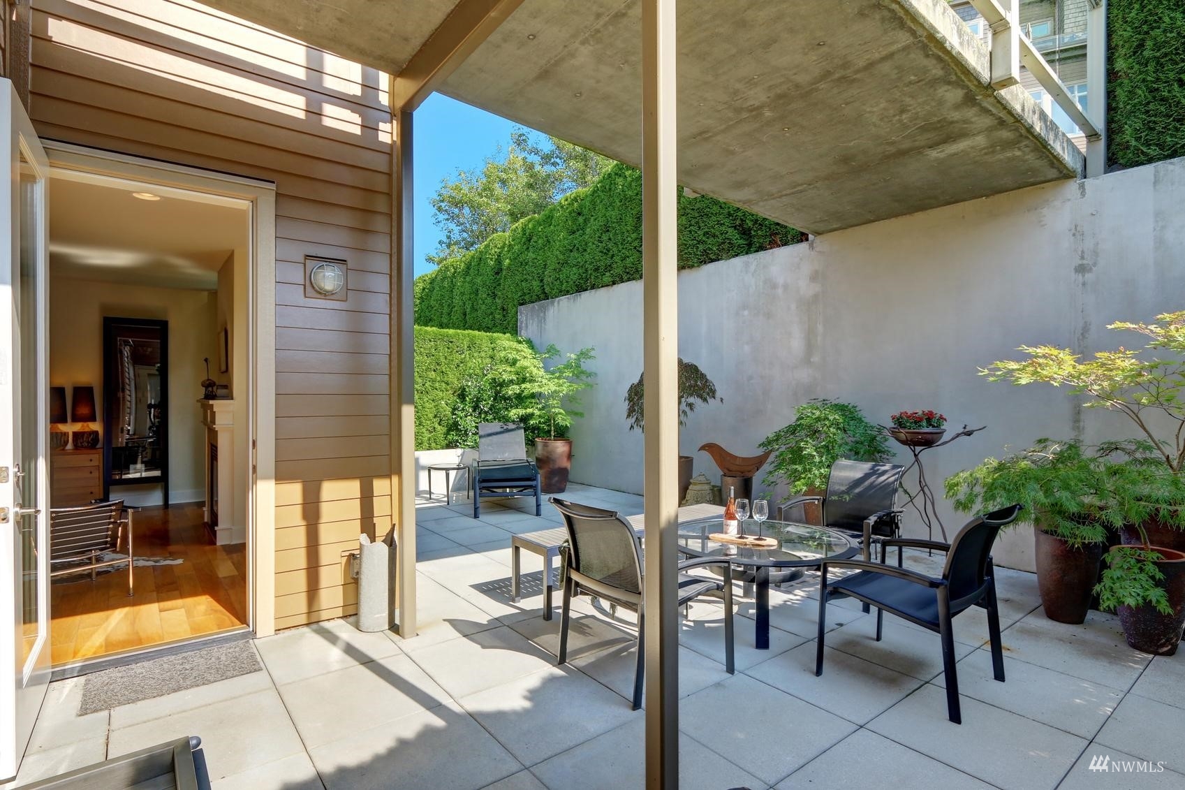 41 Pine Street, Unit 213 Edmonds, WA 98020 - Photo 18 of 25 a view of a patio with table and chairs potted plants with wooden floor