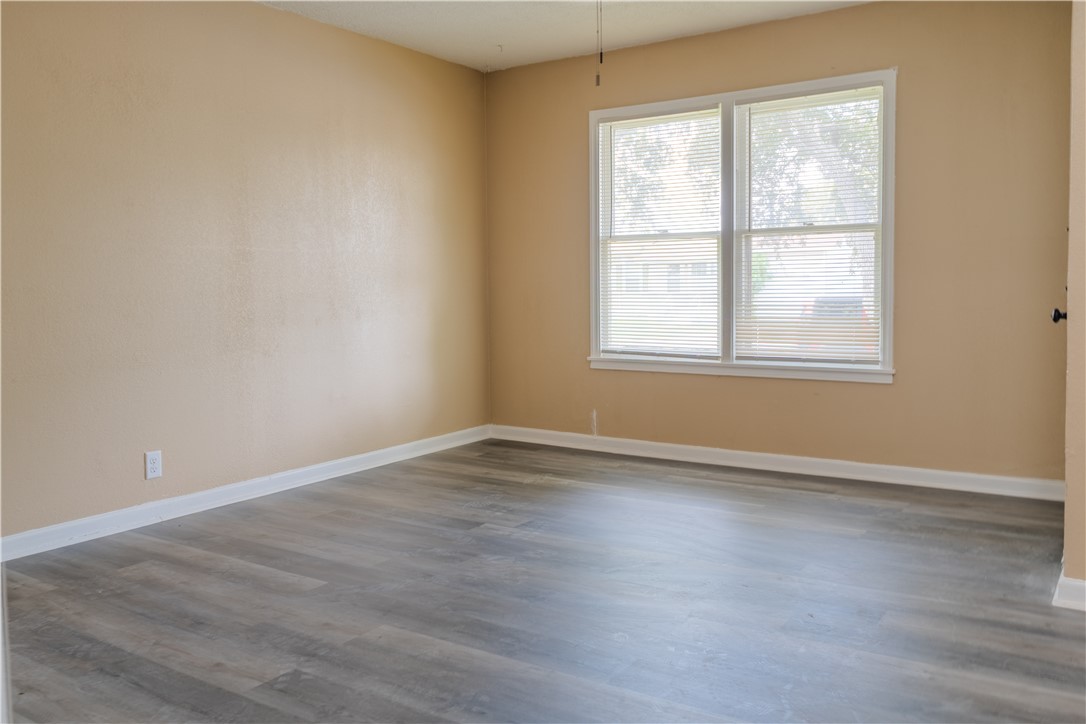 1122 Rickey Drive Corpus Christi, TX 78412 - Photo 5 of 8 an empty room with wooden floor and windows
