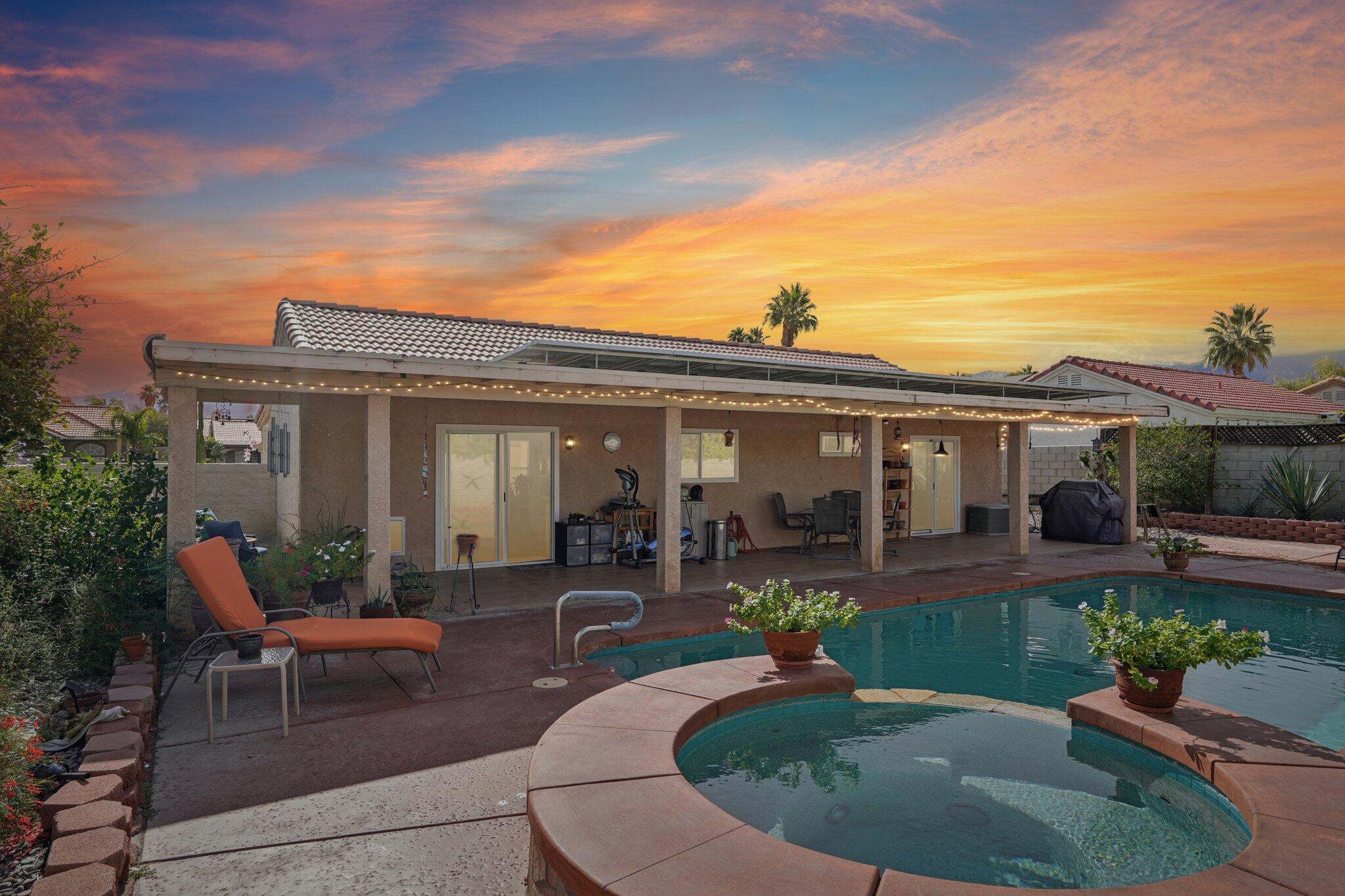 a view of a house with swimming pool and sitting area