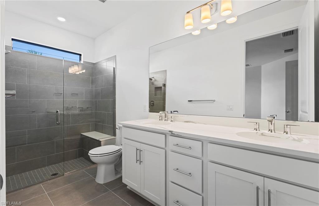 6407 Memorial Lane Ave Maria, FL 34142 - Photo 12 of 21 a bathroom with a double vanity sink mirror and toilet