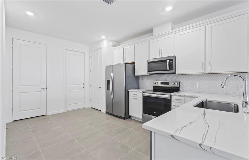 6407 Memorial Lane Ave Maria, FL 34142 - Photo 5 of 21 a kitchen with a sink a stove a refrigerator and cabinets