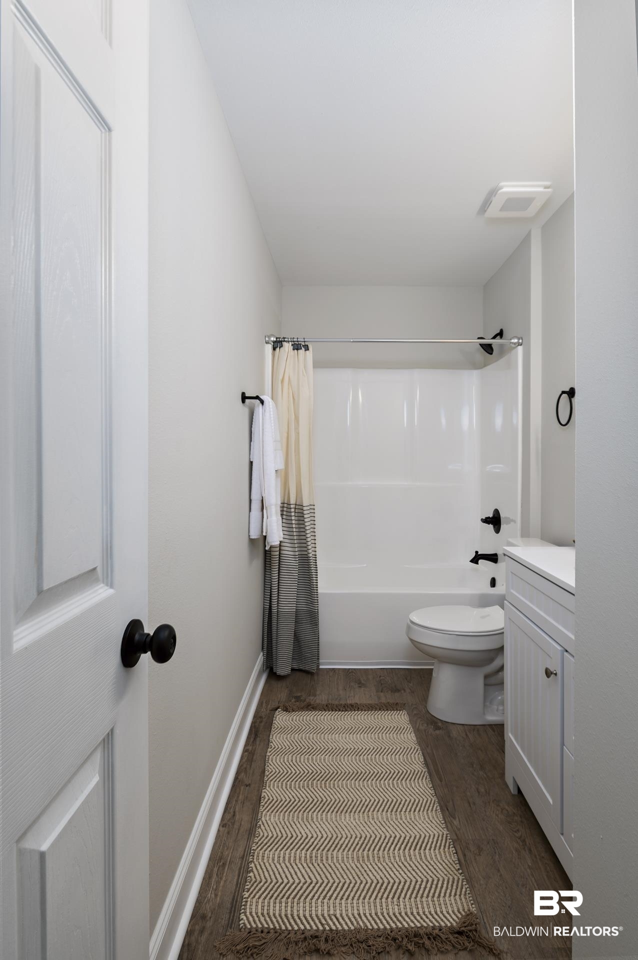 21717 Shadowbrook Street Robertsdale, AL 36567 - Photo 9 of 32 Full bath featuring shower / tub combo with curtain, toilet, vanity, wood finished floors, and baseboards