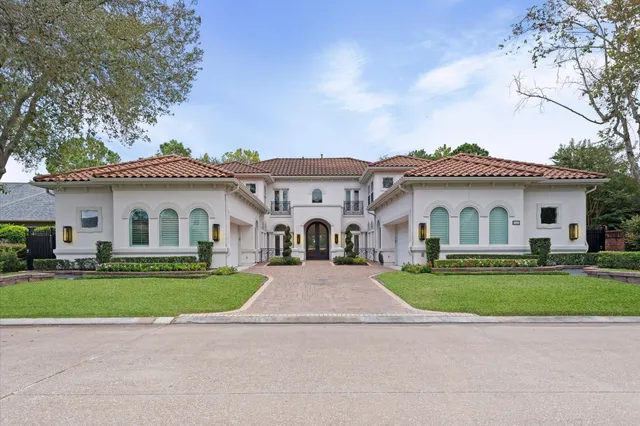 a view of a white house with a big yard and large trees