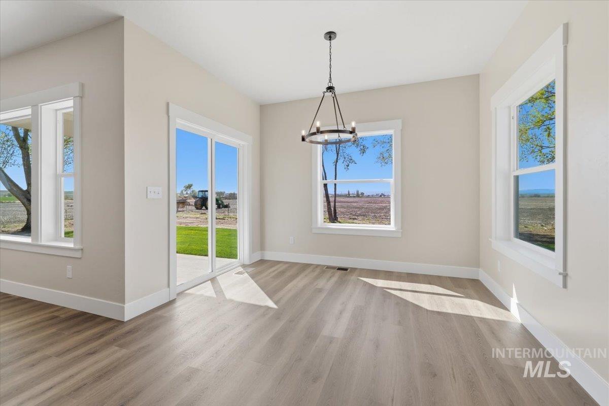 29343 Dixie Road Parma, ID 83660 - Photo 18 of 35 Unfurnished dining area with suspended lighting, light wood finished floors, and plenty of natural light