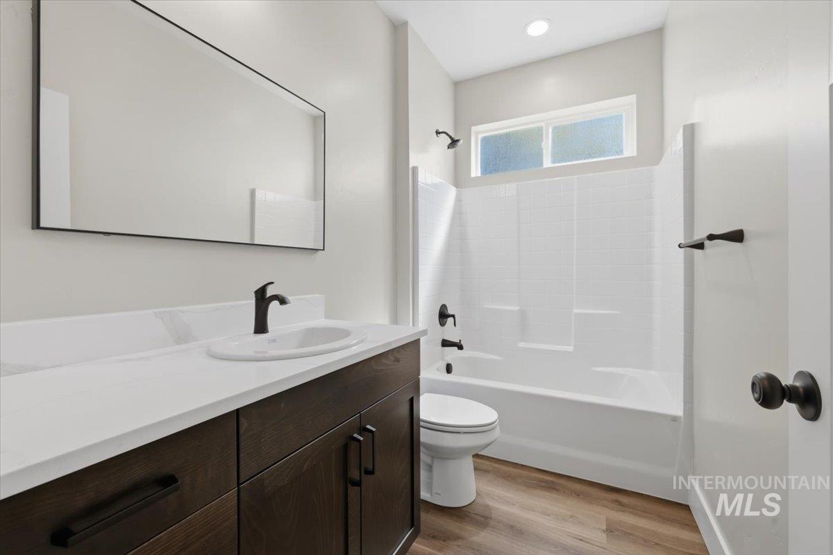 29343 Dixie Road Parma, ID 83660 - Photo 30 of 35 Bathroom with vanity, light wood finished floors, and bathing tub / shower combination