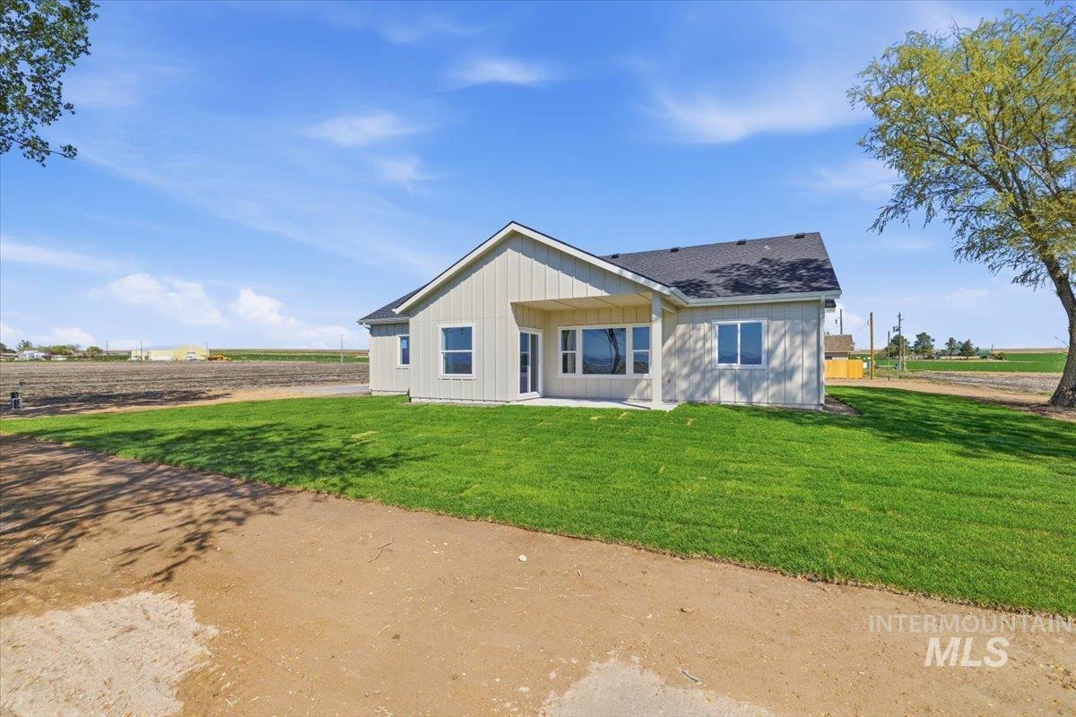 29343 Dixie Road Parma, ID 83660 - Photo 33 of 35 Rear view of house featuring a patio, a yard, a shingled roof, and board and batten siding