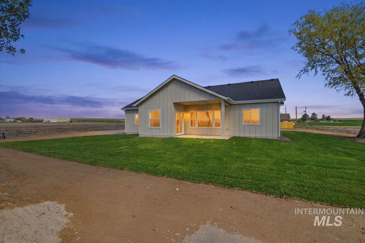 29343 Dixie Road Parma, ID 83660 - Photo 34 of 35 Back of property with a patio, board and batten siding, and a yard