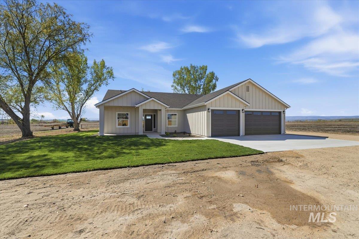 29343 Dixie Road Parma, ID 83660 - Photo 4 of 35 Modern farmhouse style home featuring driveway, a front lawn, an attached garage, and board and batten siding
