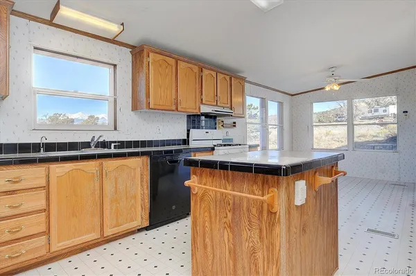 a kitchen with stainless steel appliances granite countertop a sink a stove and a refrigerator