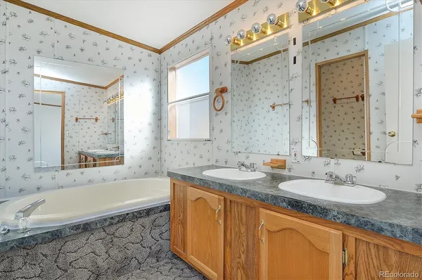 a bathroom with a granite countertop tub sink and mirror