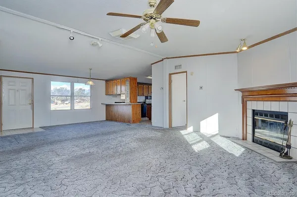 a view of empty room with a fireplace and fan
