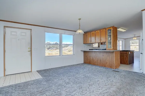 a view of kitchen with granite countertop cabinets and refrigerator