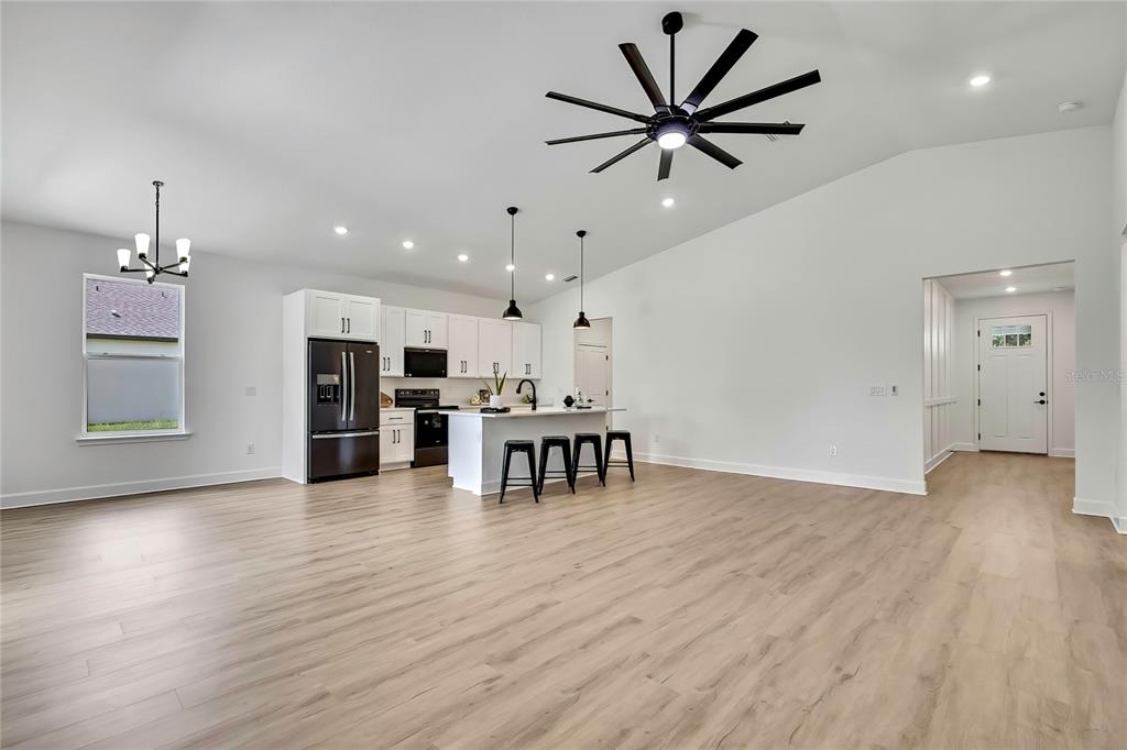 6589 Freeport Drive Spring Hill, FL 34608 - Photo 9 of 63 a view of an empty room with wooden floor and a ceiling fan