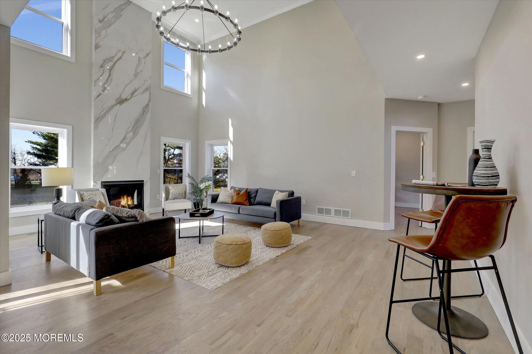 750 Holmdel Road Holmdel, NJ 07733 - Photo 12 of 55 a living room with furniture a fireplace and a chandelier