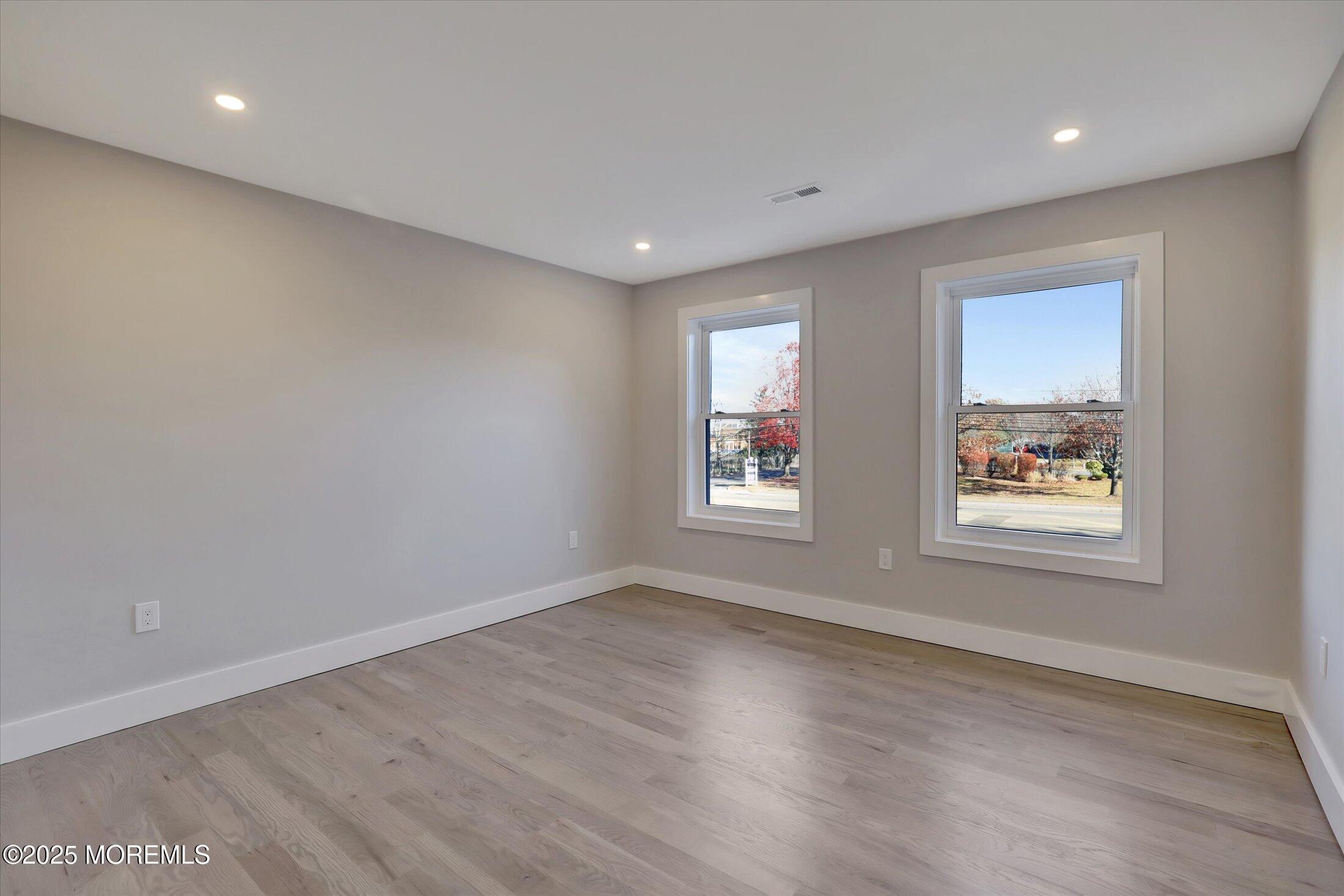 750 Holmdel Road Holmdel, NJ 07733 - Photo 40 of 55 an empty room with wooden floor and windows