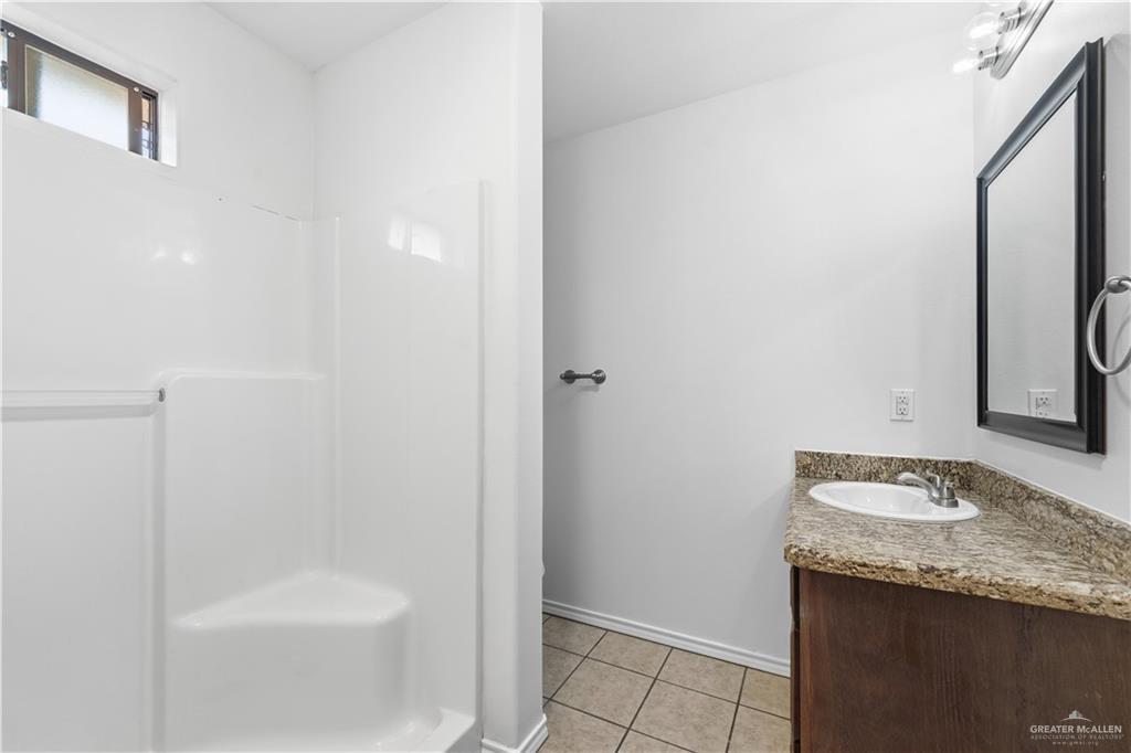 2205 Ithaca Avenue, Unit B McAllen, TX 78501 - Photo 13 of 16 a bathroom with a granite countertop sink and a mirror