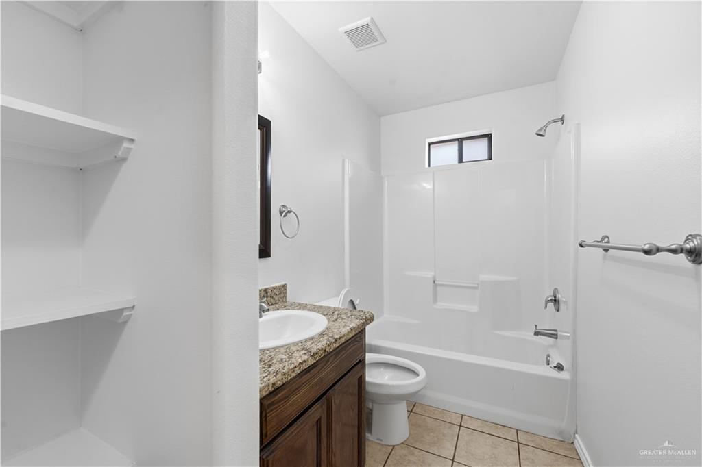 2205 Ithaca Avenue, Unit B McAllen, TX 78501 - Photo 15 of 16 a bathroom with a granite countertop sink toilet and shower