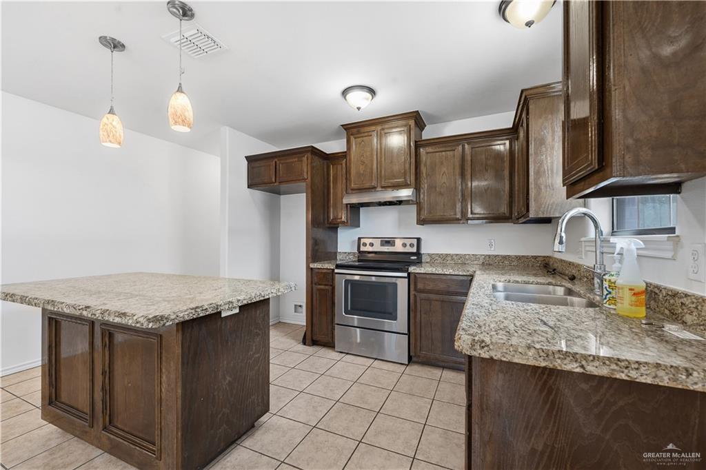 2205 Ithaca Avenue, Unit B McAllen, TX 78501 - Photo 6 of 16 a kitchen with stainless steel appliances granite countertop a sink stove and refrigerator
