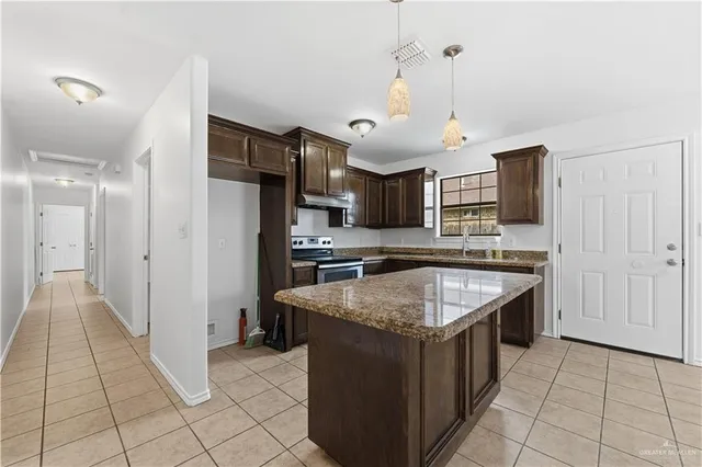 a kitchen with stainless steel appliances granite countertop a sink and a refrigerator